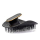 Black hairbrush with gold accents on a white background