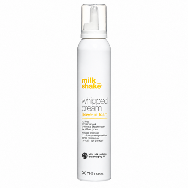 A white cylindrical pump bottle of milk shake Whipped Cream Leave-In Foam on a plain white background.