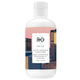 A 250 mL bottle of R+Co Dallas Biotin Thickening Conditioner, featuring a white bottle with a pink and multicolor cityscape label.