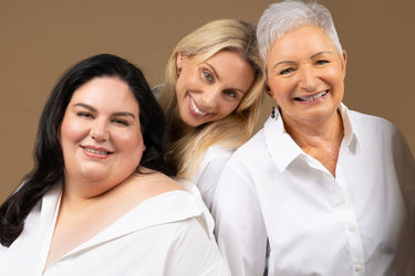 Group of women wearing matching white shirts smiling to the camera