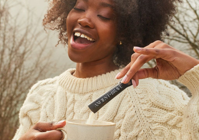 Smiling lady taking her Ancient + Brave supplements