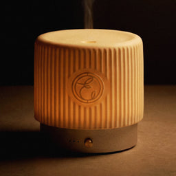 Ceramic diffuser with a logo on a dark background