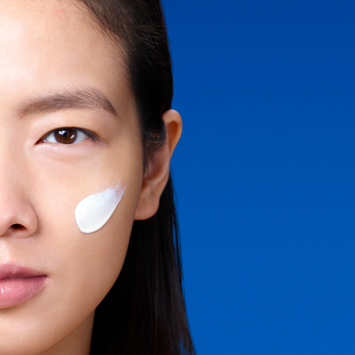 model with the serum on their cheek