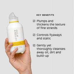 Hand holding a Philipley hair product bottle with key benefits listed on a light gray background