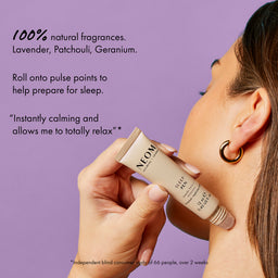 Person applying NEOM sleep balm to their neck with a purple background