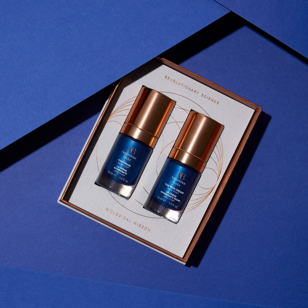 Two skincare bottles on a branded box against a blue background