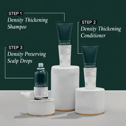 Density hair care product set with shampoo, conditioner, and scalp drops on a white surface against a dark green background.