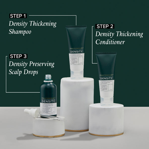 Density hair care product set with shampoo, conditioner, and scalp drops on a white surface against a dark green background.