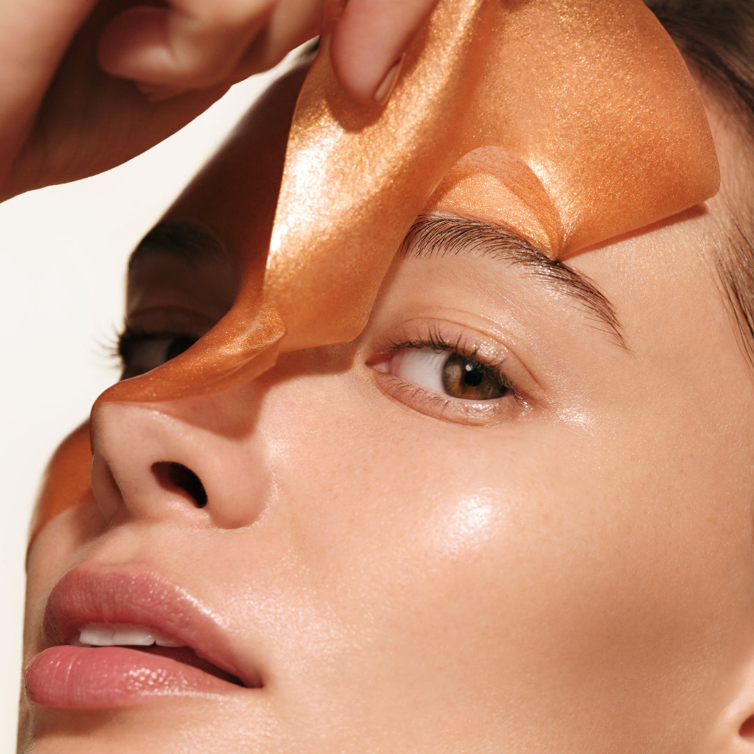 Close-up of a woman's face with an orange mask on her forehead