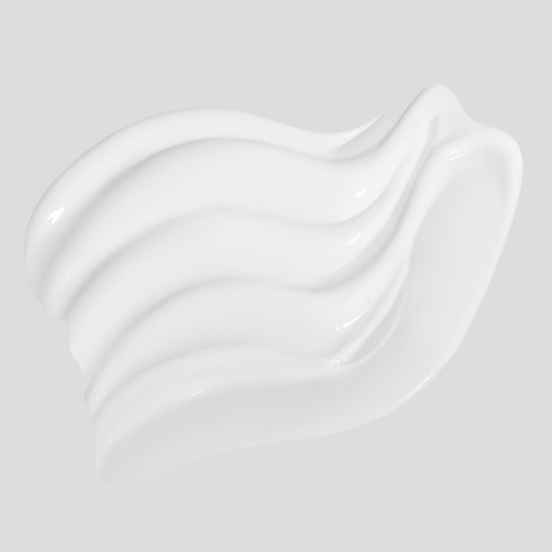 White cream smear on a light gray background