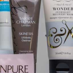 Collection of skincare products including a tube of Sarah Chapman Skinesis Ultimate Cleanse and a tube of Percy & Reed's Wonder Overnight Recovery Mask.