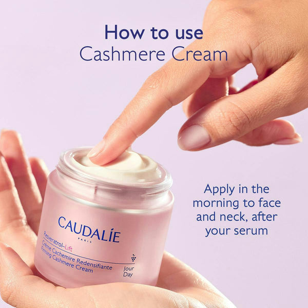 A hand scoops cream from a jar of Caudalie Paris Cashmere Cream, held in another hand, with instructional text on a light lavender background.