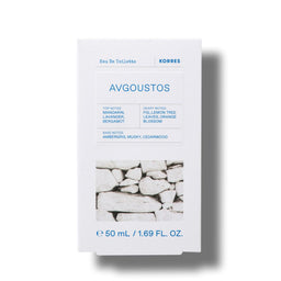 A white rectangular box of KORRES Avgoustos Eau De Toilette, featuring blue text and a black-and-white photograph of stacked stone walls near the bottom, set against a plain white background with a soft drop shadow.