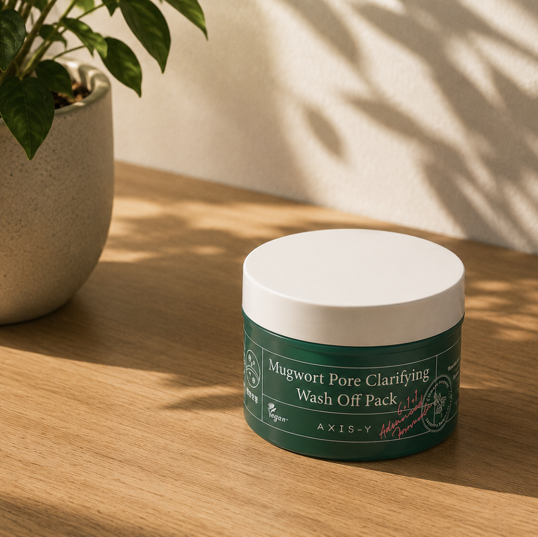 Green jar of Mugwort Pore Clarifying Wash Off Pack on a wooden surface with a plant in the background