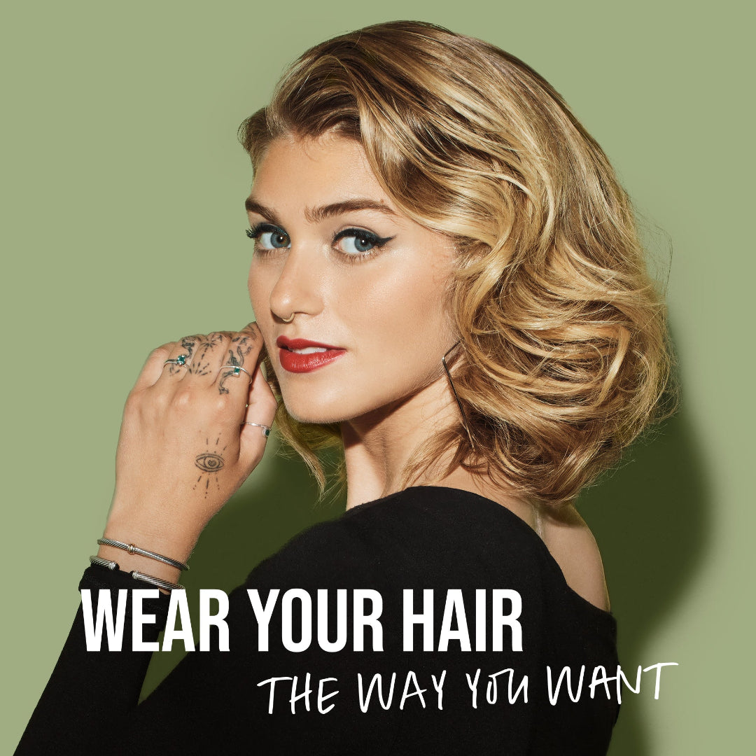 Woman with styled hair against a green background with text 'Wear Your Hair The Way You Want'.
