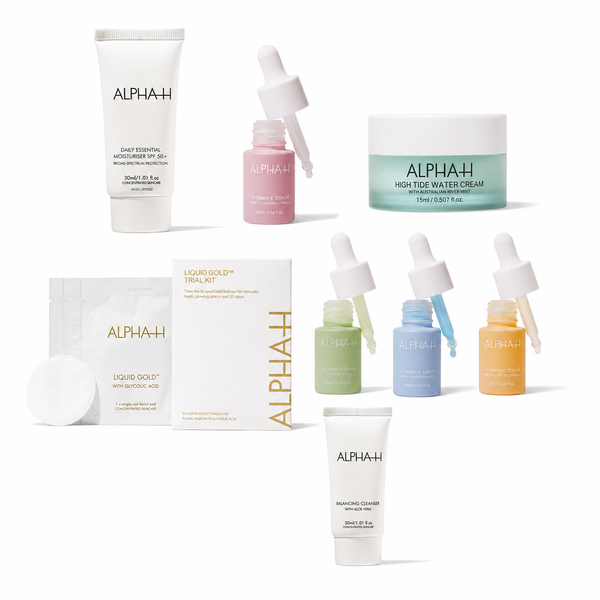 A collection of skincare products from the brand ALPHAH, including a Daily Essential Moisturizer, a Liquid Gold Trial Kit box and cotton pad, a Forster Water Cream jar, and several small serum dropper bottles in pink, green, blue, and orange, all arranged on a clean white background.