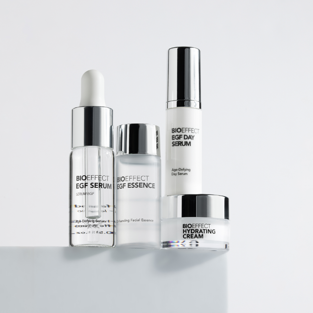 Set of skincare products including a serum, essence, and cream on a white background