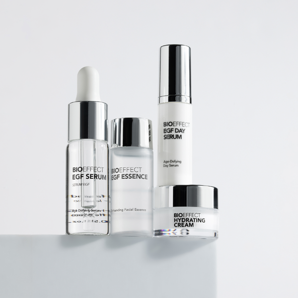 Set of skincare products including a serum, essence, and cream on a white background