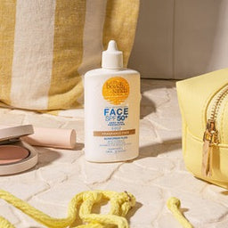 a bottle of Bondi Sands SPF 50+ Fragrance Free Face Fluid on a stone surface