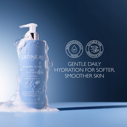 Gatineau Renewal Ultimate AHA body wash in a light blue pump bottle, shown with white foam around the base on a blue gradient background. White text on the right reads 'GENTLE DAILY HYDRATION FOR SOFTER, SMOOTHER SKIN' with two circular icons above.