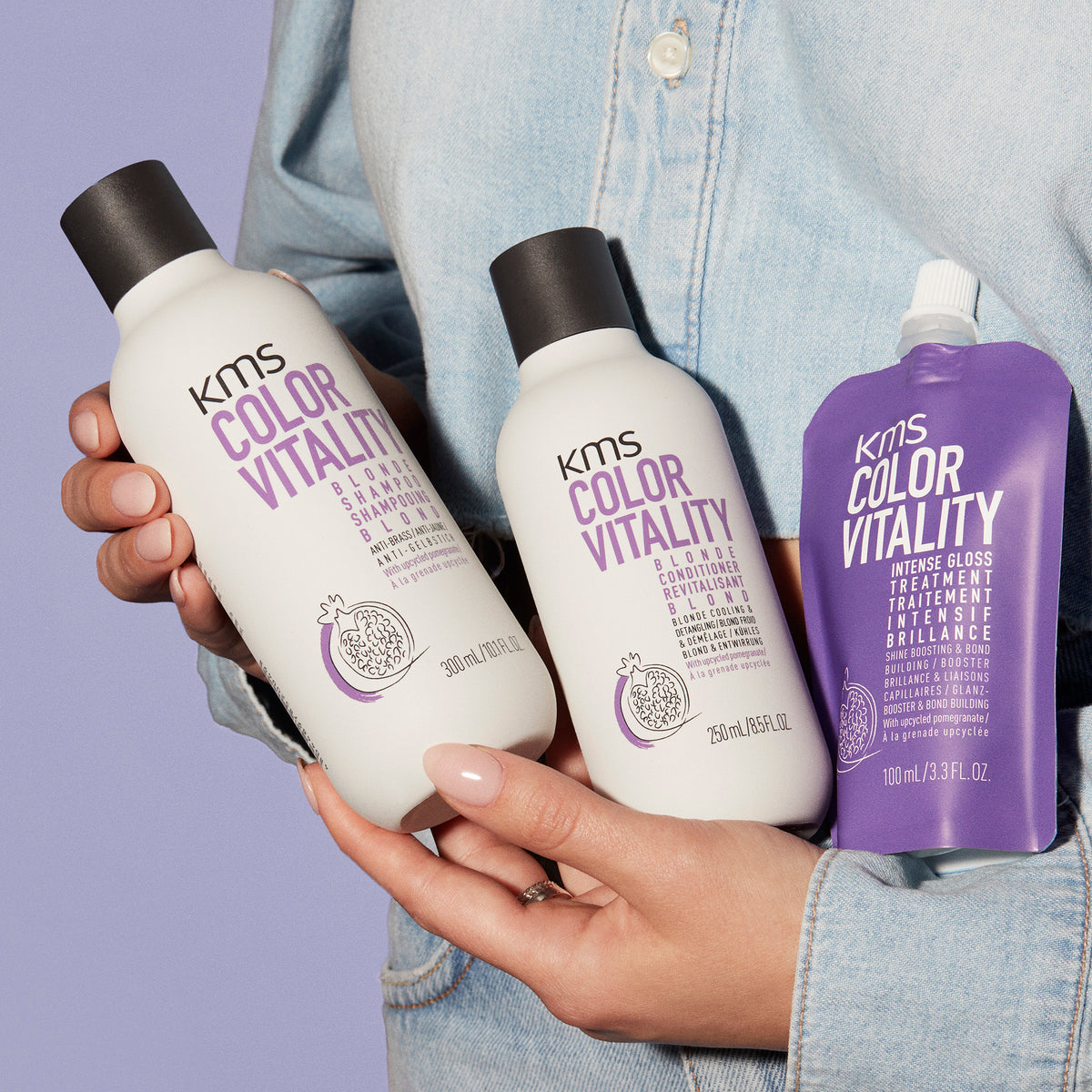 KMS Color Vitality hair care products held by a person against a purple background
