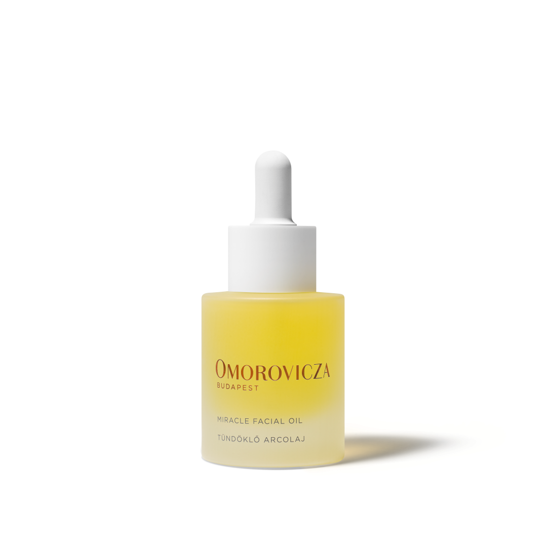 A bottle of Omorovicza Miracle Facial Oil with a white dropper cap, containing a pale yellow liquid, set against a clean white background.