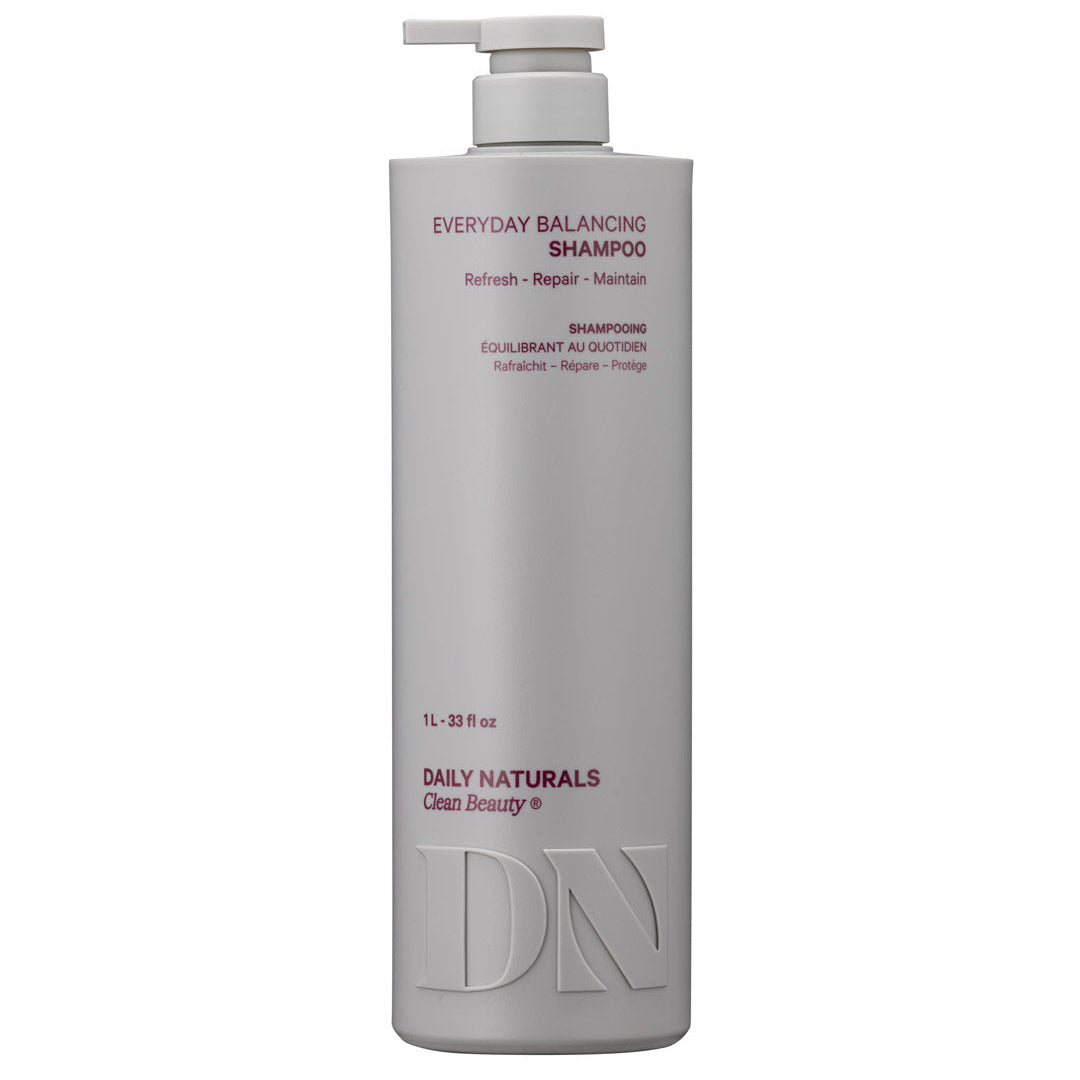 A tall, matte light gray pump bottle of Daily Naturals Everyday Balancing Shampoo on a plain white background.