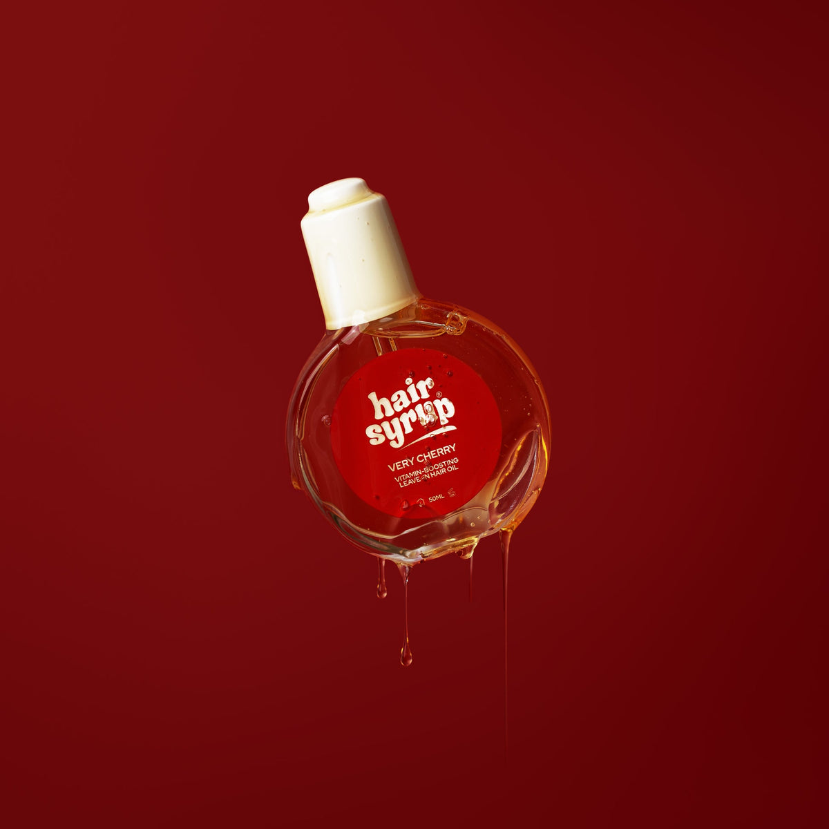 Bottle of 'hair syrup' with a red label on a red background