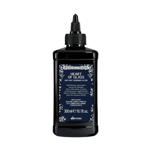 A 300ml black plastic bottle of Davines Heart of Glass Instant Bonding Glum with a black cap, featuring a dark navy blue label with white floral borders and text.