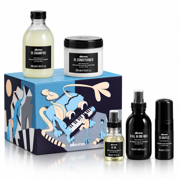 Davines men's grooming gift set featuring a blue illustrated box, a bottle of oi shampoo, a jar of oi conditioner, a bottle of oi oil, a bottle of oi all in one milk, and a bottle of oi boutine, arranged on a white background.