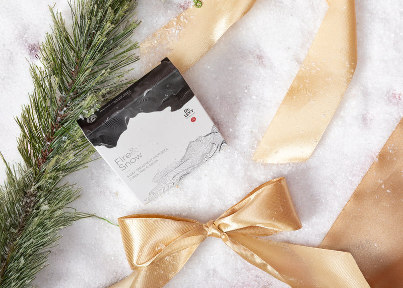 Gift with gold ribbon and 'Frost & Snow' card on a snowy background