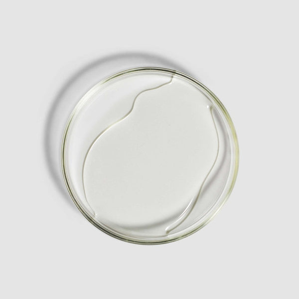 Clear glass plate with a white ceramic core on a light gray background