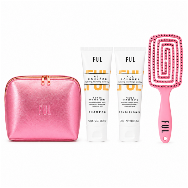A FUL brand hair care set on a white background, featuring a metallic pink zippered pouch, a tube of shampoo, a tube of conditioner, and a pink hairbrush with rhinestones.