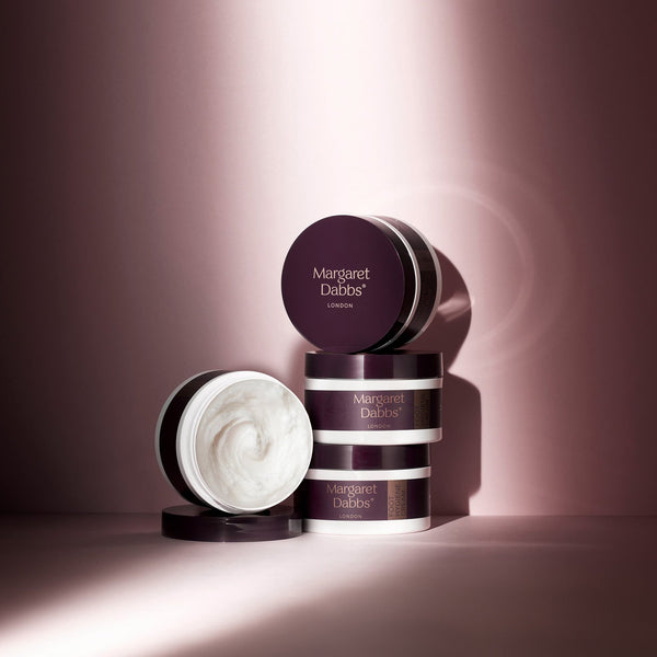 Skincare products with 'Margaret Dabbs' branding on a pink background