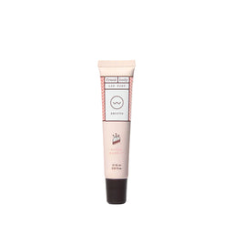 A pink squeeze tube of Frank Body Lip Balm in the 'Juicy Orange' scent, featuring a black cap, centered on a light gray background.