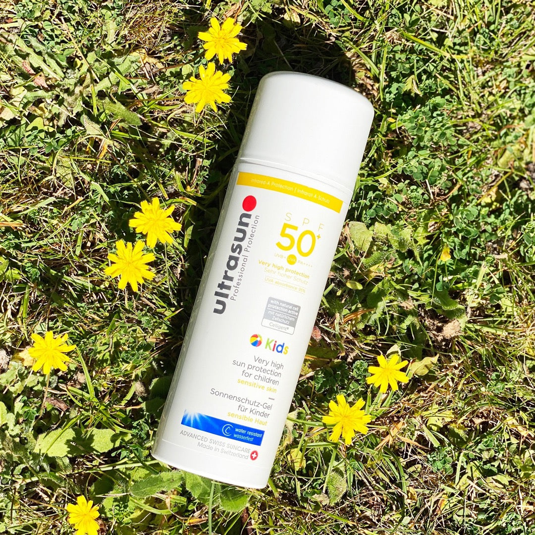 White Ultrasun Kids SPF 50+ bottle on grass
