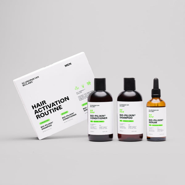Hair care product set including shampoo, conditioner, and serum with packaging on a gray background
