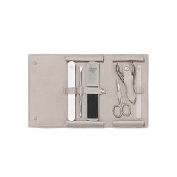 Manicure set with tools on a beige fabric case against a white background