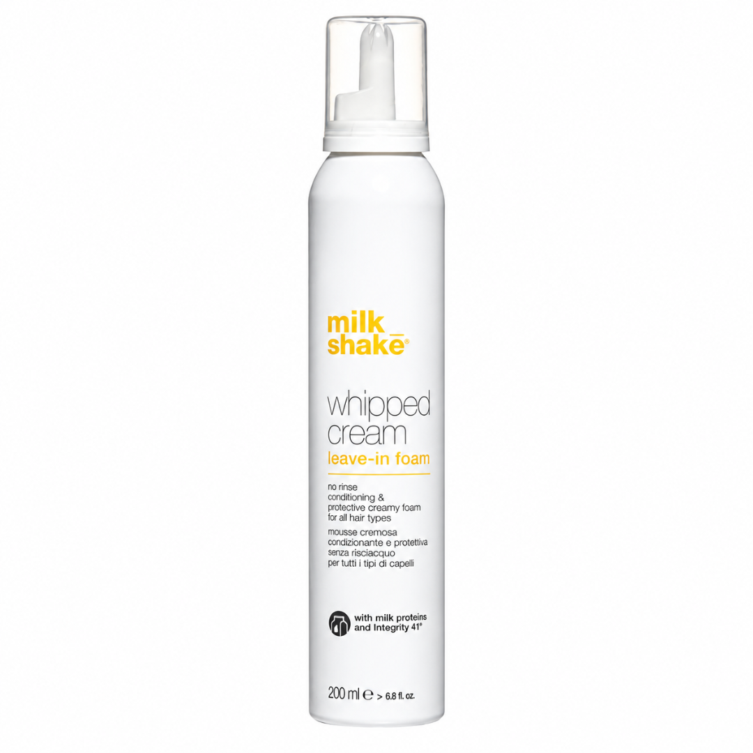 A white cylindrical pump bottle of milk shake Whipped Cream Leave-In Foam on a plain white background.