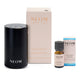 NEOM Welcoming Pod Mini diffuser set on a white background, including the matte black cylindrical diffuser, its cream-colored packaging box, a small amber essential oil bottle, and a blue-accented product box.