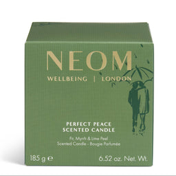 A square green box of NEOM Wellbeing London 'Perfect Peace' scented candle, featuring gold lettering and a dark green silhouette of a couple under an umbrella, on a white background.