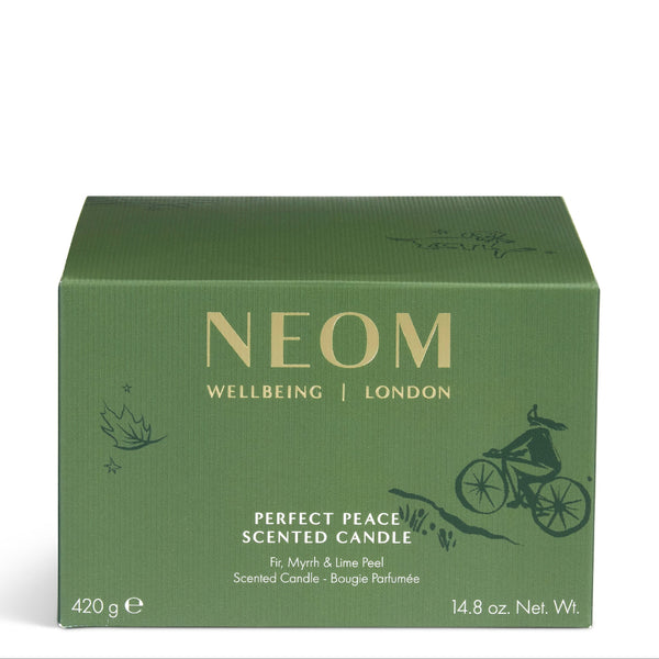 A green rectangular box of NEOM Wellbeing London 'Perfect Peace' scented candle, featuring gold lettering and a black line art illustration of a cyclist, set against a plain white background.