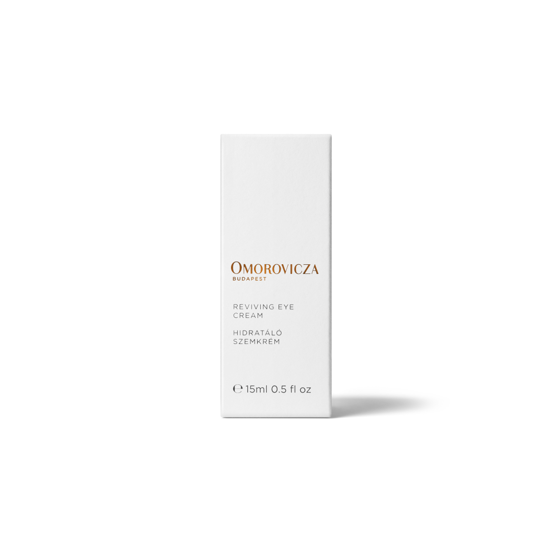 Omorovicza Budapest Reviving Eye Cream in a tall, minimalist white rectangular box with elegant gold and black text, set against a clean white background with a soft shadow.