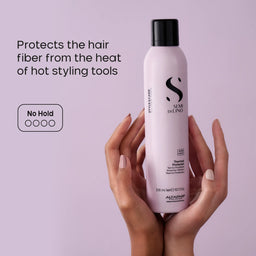 Hand holding a bottle of Alfaparf Semi Di Lino hair product against a light purple background