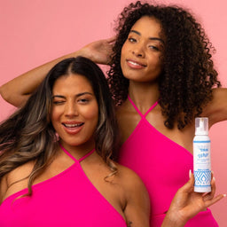 two women holding Skinny Tan Self-Tanning Whip Dark to the camera