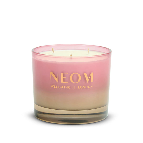 Neom candle with pink and beige gradient on a white background