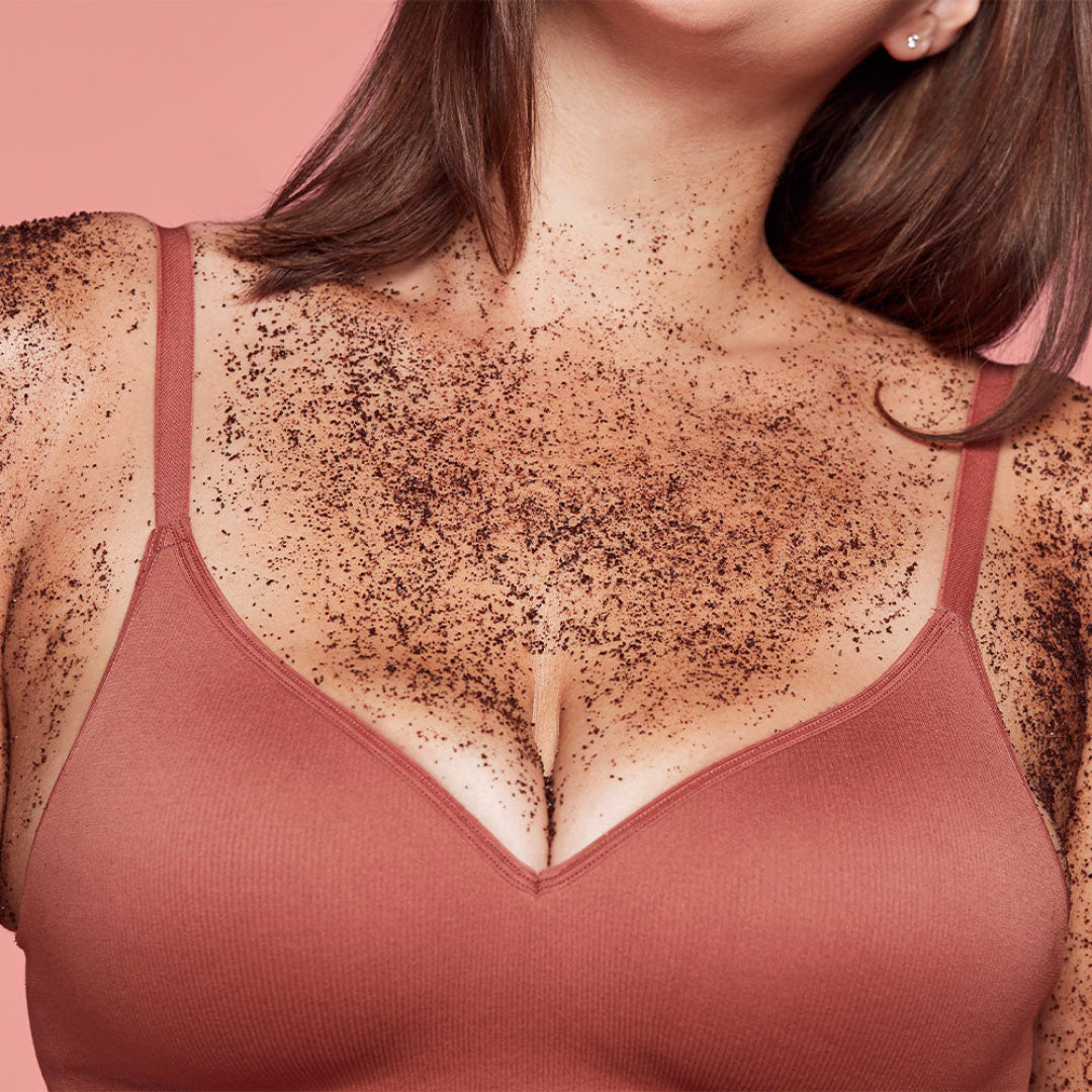 Woman wearing a pink bra with chest hair on a pink background