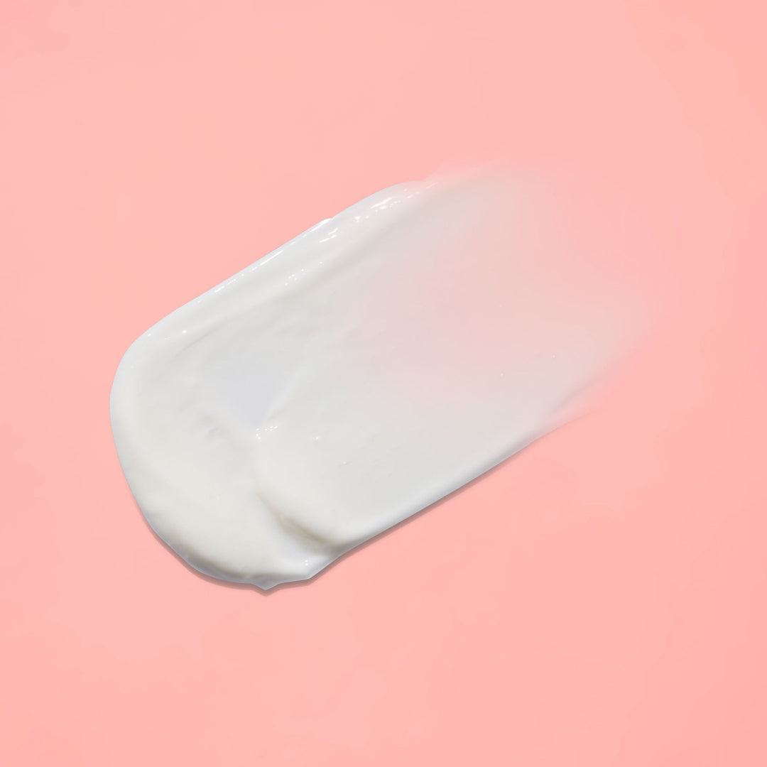 White cream smear on a pink background