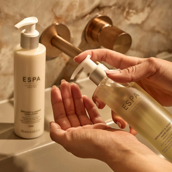 Person holding a bottle of ESPA hand wash with another bottle in the background.