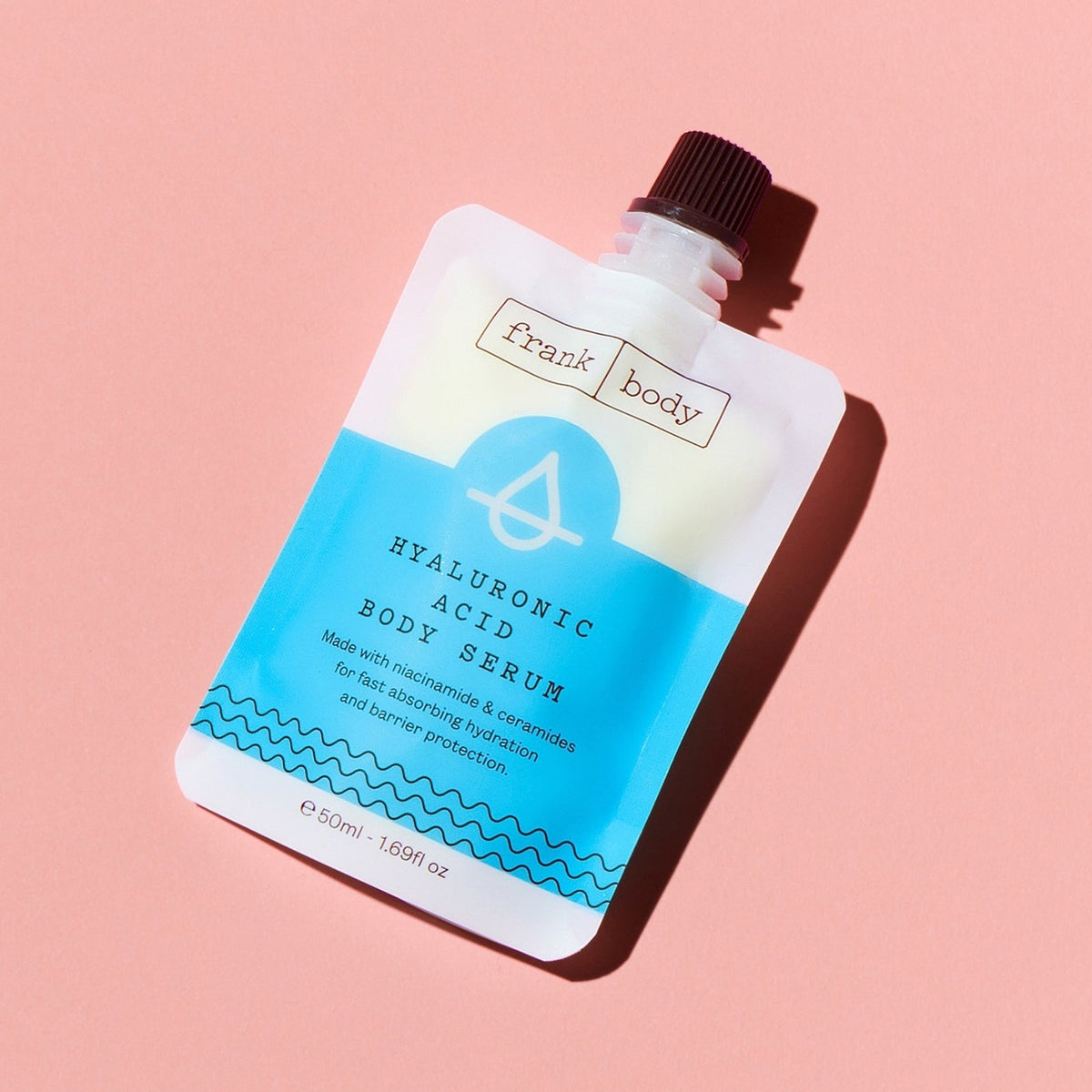 Skincare serum packaging with blue and white design on a pink background